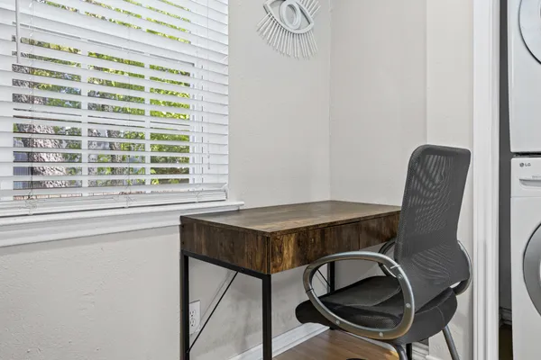 a view of a workspace with furniture and a window
