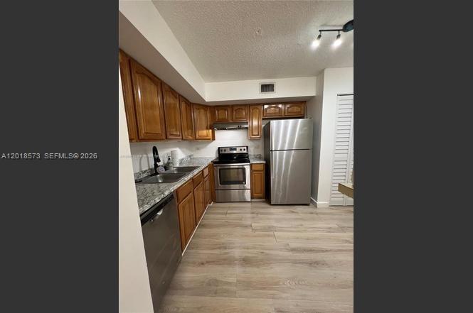 3700 North 56th Avenue, Unit 1012 Hollywood, FL 33021 - Photo 2 of 11 a large kitchen with a stove a refrigerator and a sink