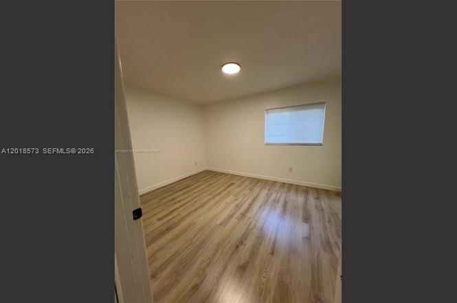 3700 North 56th Avenue, Unit 1012 Hollywood, FL 33021 - Photo 7 of 11 an empty room with wooden floor and windows