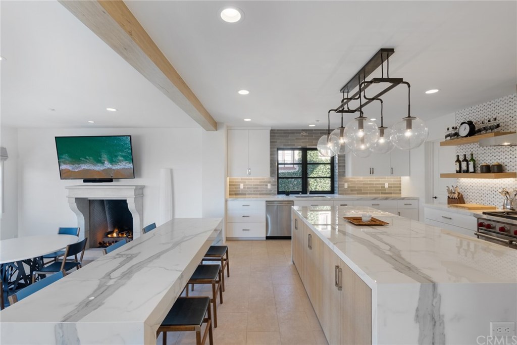 4 Emerald Bay Laguna Beach, CA 92651 - Photo 48 of 75 a kitchen with kitchen island a stove a sink a refrigerator and a dining table with wooden floor