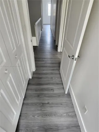 a view of a hallway with wooden floor and staircase