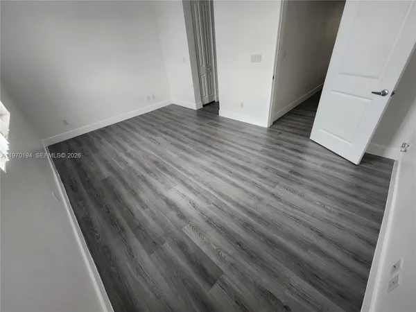 an empty room with wooden floor and stairs