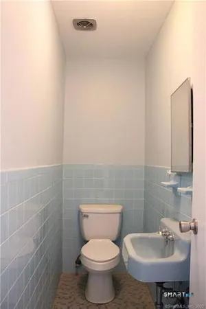 a bathroom with a sink toilet and a mirror