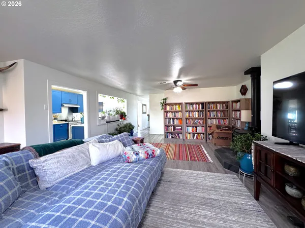 a bed sitting in a spacious bedroom next to a window and chandelier