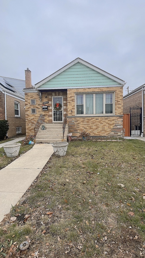 Undisclosed Address Chicago, IL 60629 - Photo 2 of 18 a front view of a house with a yard and garage