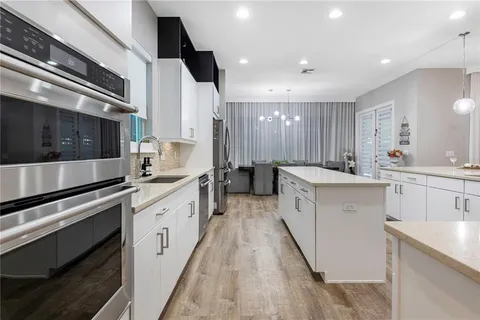 a kitchen with stainless steel appliances granite countertop a sink and a stove