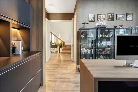 a spacious bedroom with a bed and a flat tv screen on dresser