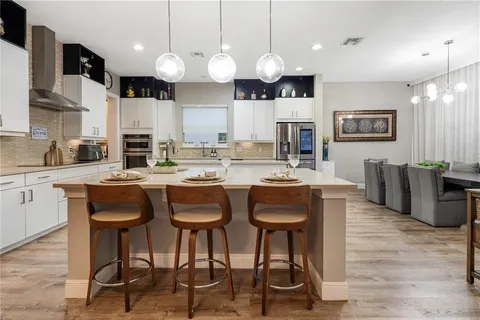 a large white kitchen with stainless steel appliances sink and cabinets