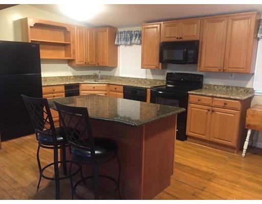 39 Sled Road Ashburnham, MA 01430 - Photo 4 of 23 a kitchen with stainless steel appliances granite countertop a stove a sink a microwave a dining table and chairs