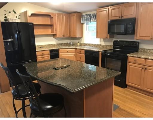 39 Sled Road Ashburnham, MA 01430 - Photo 5 of 23 a kitchen with a stove a sink a microwave a dining table and chairs
