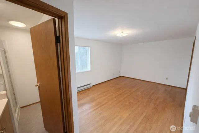 an empty room with wooden floor and entrance