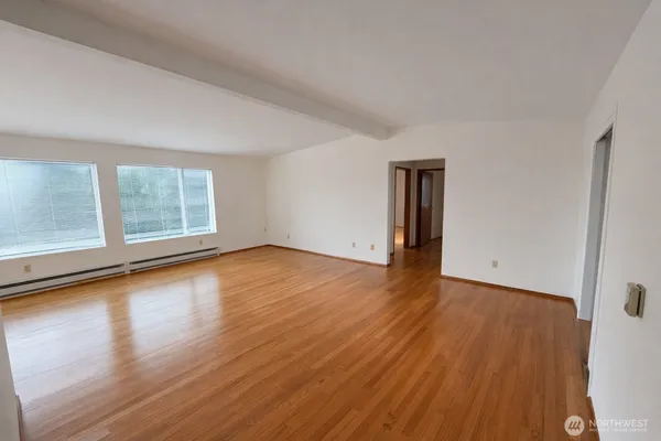 a view of a room with wooden floor and window