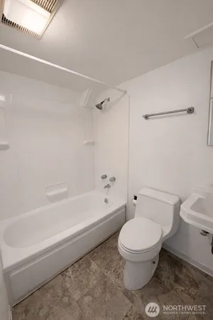 a bathroom with a toilet and a bath tub