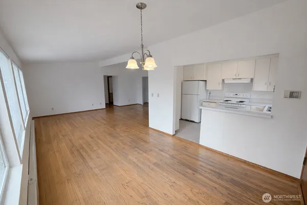 a view of a kitchen with a sink and dishwasher a refrigerator with wooden floor