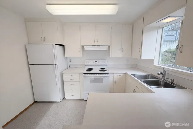 a kitchen with white cabinets and white appliances