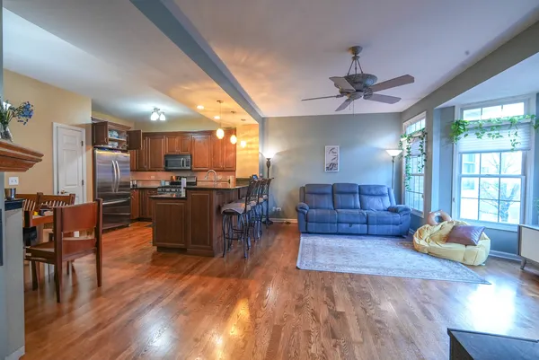 a living room with furniture dining table a flat screen tv and kitchen view