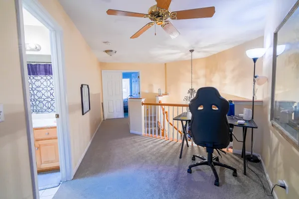 a view of a workspace with furniture and a window