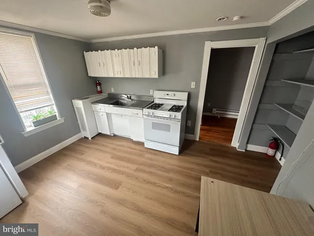 a kitchen with a stove a refrigerator and a wooden floor