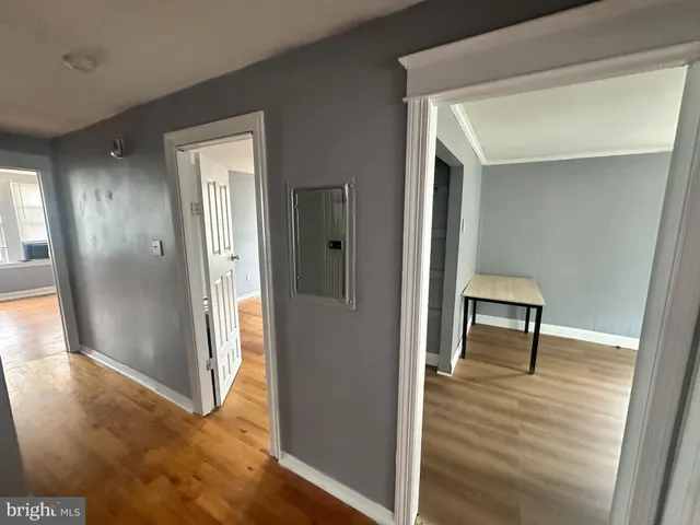 a view of a hallway with wooden floor and furniture
