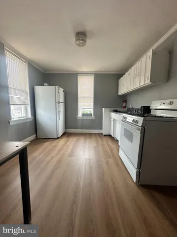 a kitchen with wooden floors and appliances