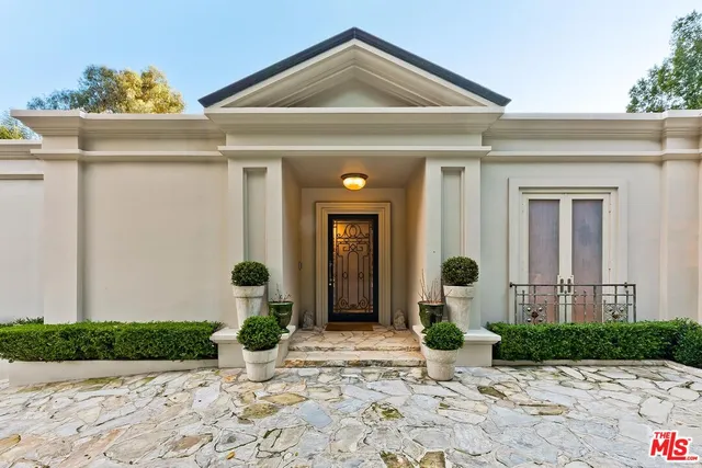 a view of a house with potted plants