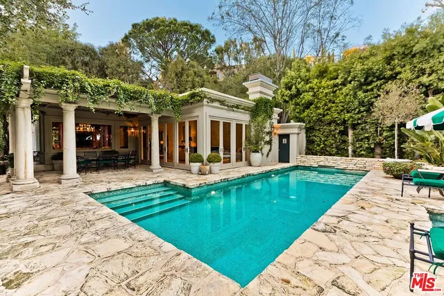 a view of a house with a swimming pool and a yard