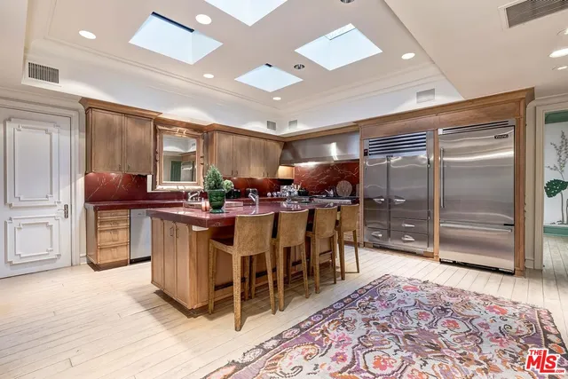 a room with lots of wooden furniture a rug and windows