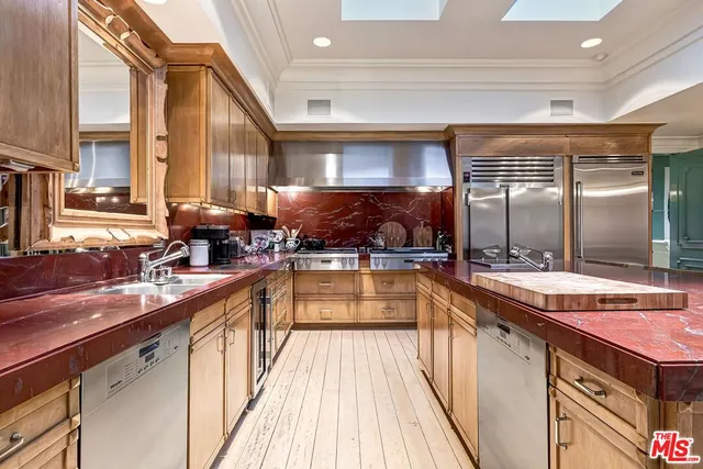 a kitchen with stainless steel appliances a sink stove and cabinets