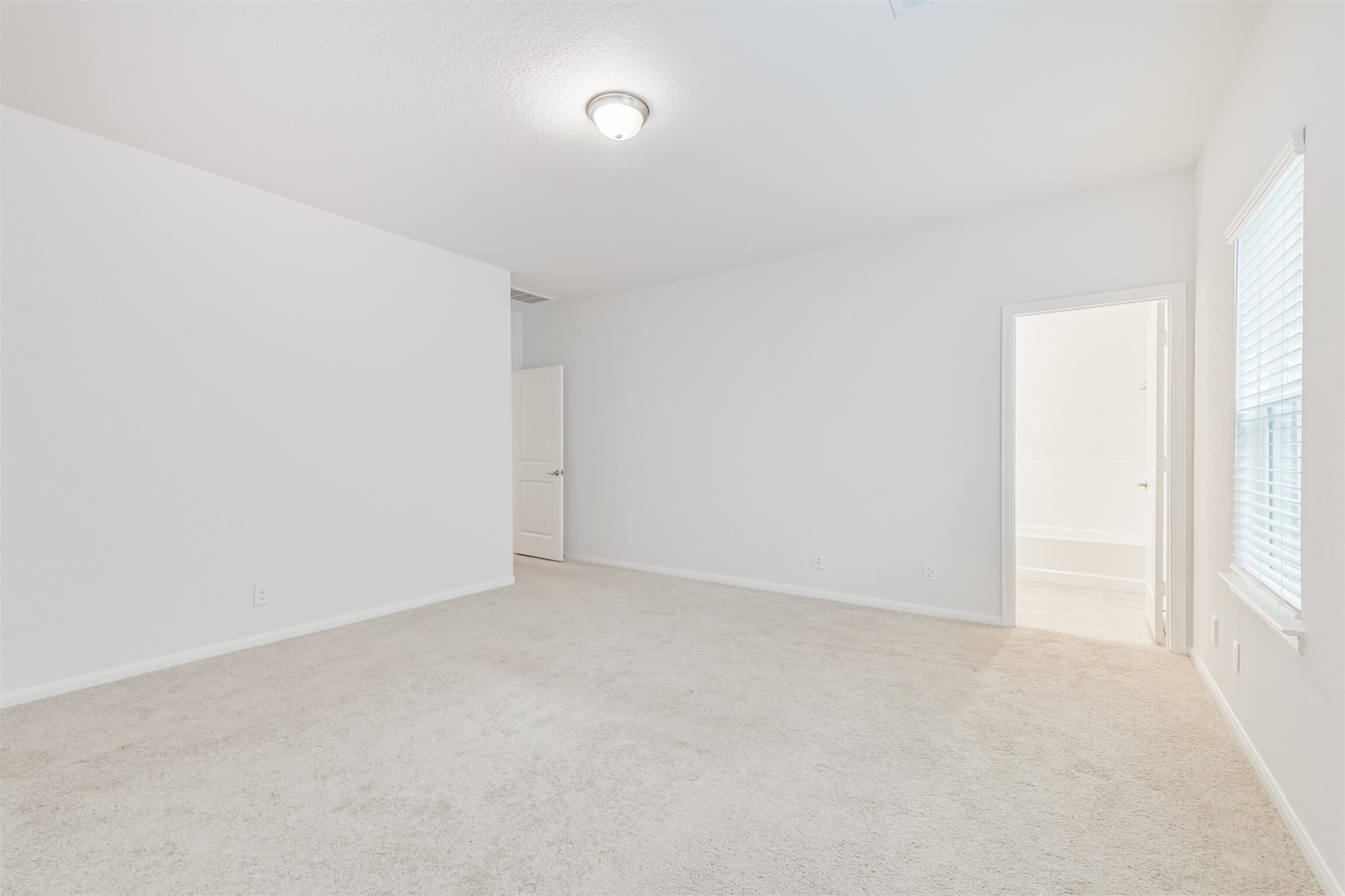 2129 Solstice Boulevard Spring, TX 77386 - Photo 26 of 49 Primary Bedroom:
Spacious primary bedroom with soft neutral carpet, great natural light, and a calm, open layout. Direct access to the en-suite primary bathroom for added convenience.