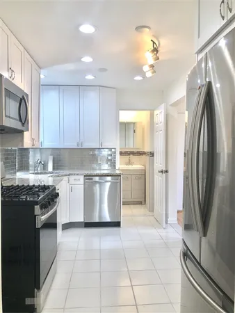 a kitchen with a sink a refrigerator and cabinets