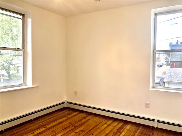 a view of a room with wooden floor and windows