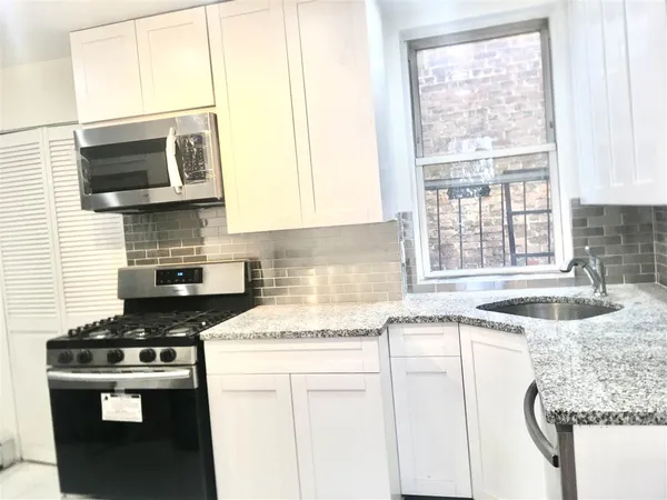 a kitchen with stainless steel appliances granite countertop a sink stove and microwave