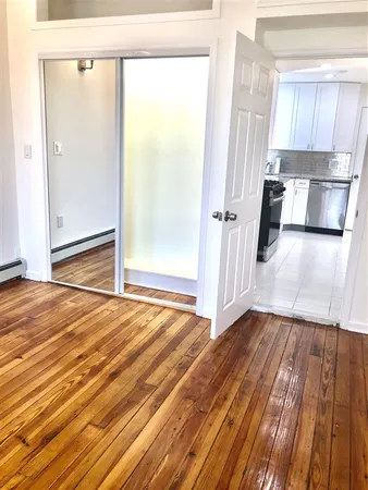 a view of a room with wooden floor and a window