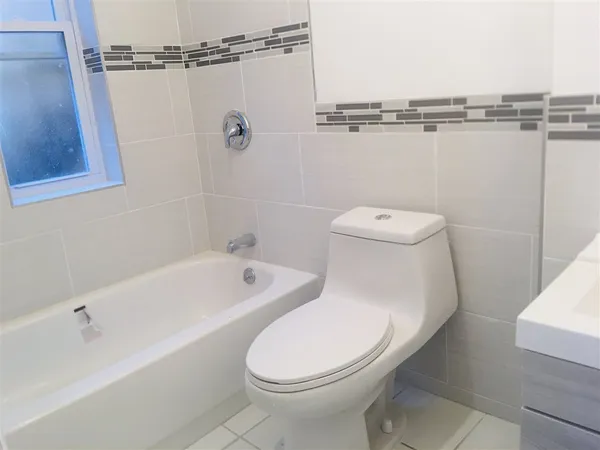 a white toilet sitting next to a bath tub and shower