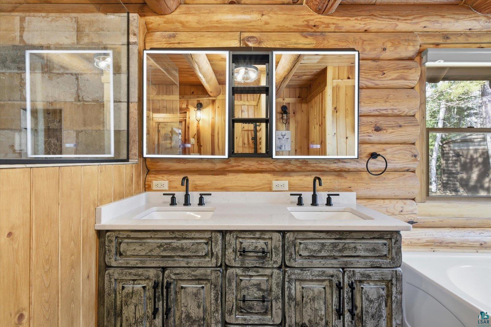7185 Giants Ridge Road Embarrass, MN 55732 - Photo 24 of 47 Dual basin vanity with a light-toned countertop, integrated sinks, and matte black fixtures