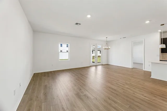 an empty room with wooden floor and window