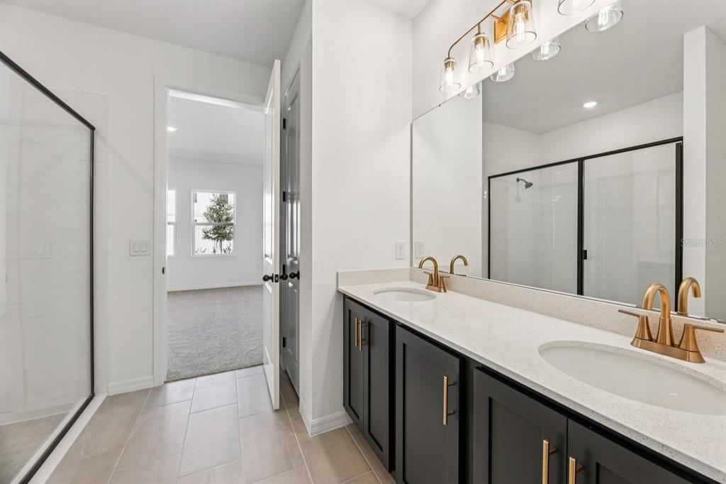 5721 Haystack Drive St. Cloud, FL 34771 - Photo 28 of 36 a bathroom with a double vanity sink mirror and shower