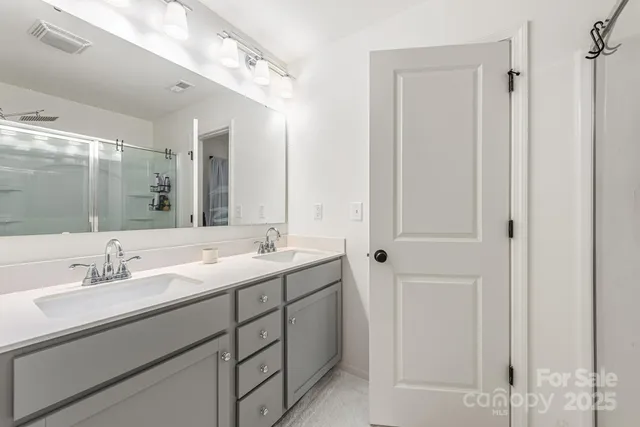 a bathroom with a double vanity sink and mirror