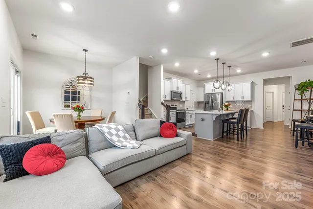 a living room with furniture and kitchen view
