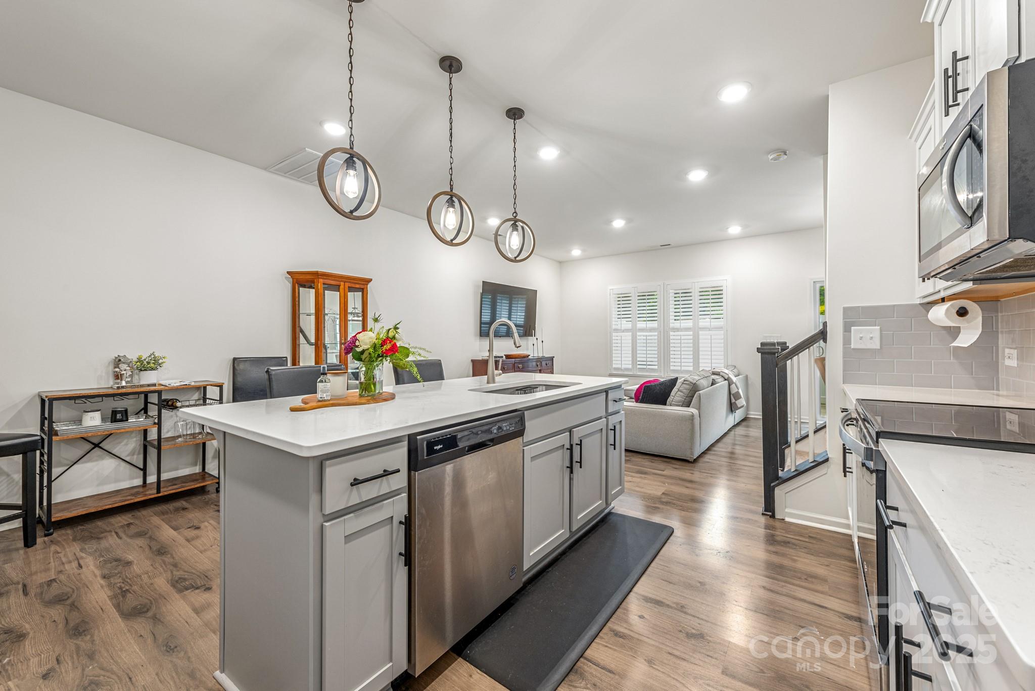 2038 Crooked Oak Lane, Unit 16 York, SC 29745 - Photo 9 of 24 a large kitchen with stainless steel appliances a stove a sink dishwasher and a fireplace with wooden floor