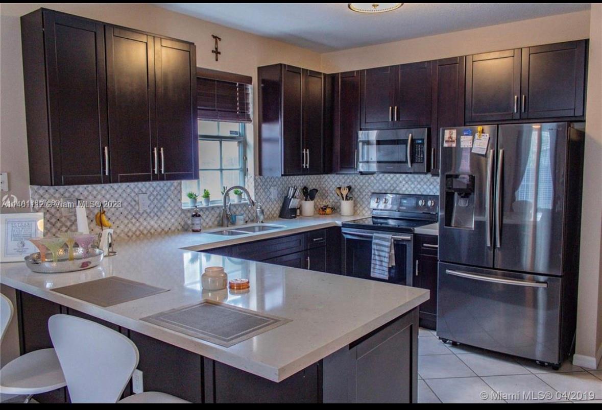The Hammocks Miami, FL 33196 - Photo 7 of 9 a kitchen with kitchen island granite countertop stainless steel appliances a sink and a refrigerator