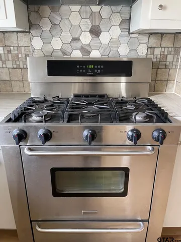 a stove top oven sitting inside of a kitchen