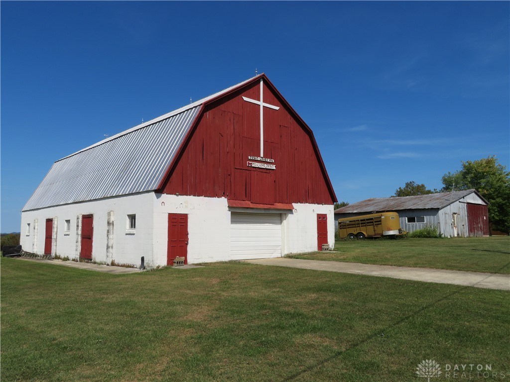748 Inlow Avenue Peebles, OH 45660 - Photo 37 of 61 This charming red and white barn features a metal roof, offering both rustic appeal and durability.