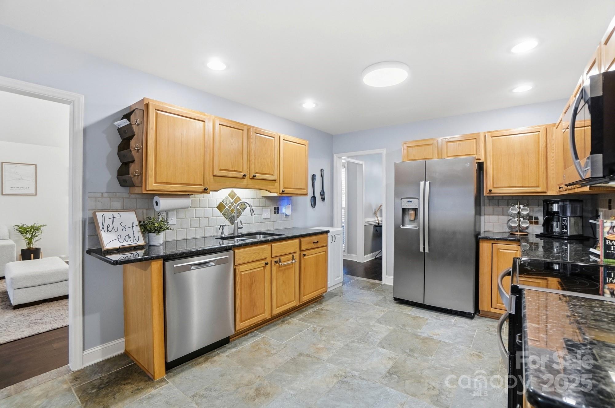 516 Jim Parker Road Monroe, NC 28110 - Photo 12 of 37 a kitchen with stainless steel appliances granite countertop a sink a stove and a refrigerator