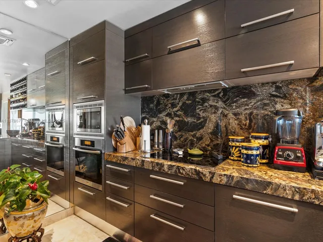 a kitchen with stainless steel appliances granite countertop a refrigerator and a stove