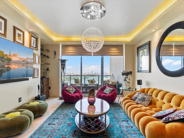 a living room with furniture a chandelier and a large window