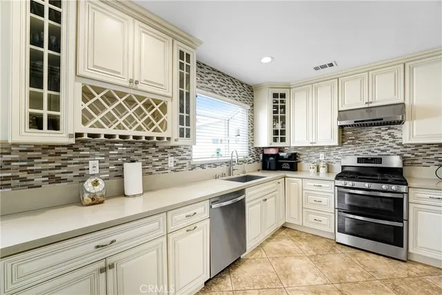a kitchen with cabinets appliances a sink and a window