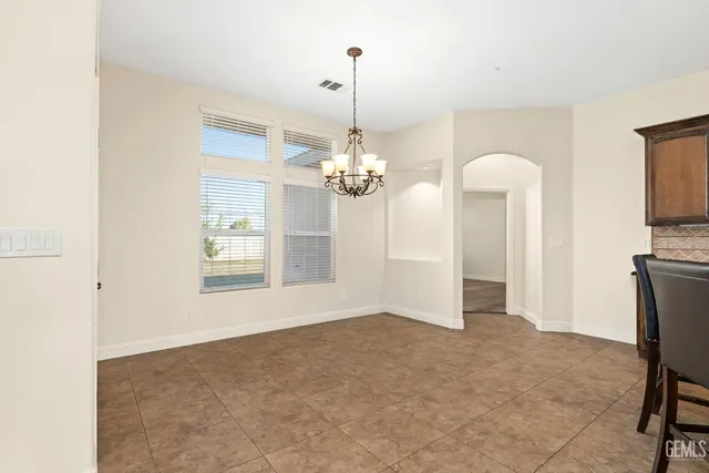 a kitchen with granite countertop a table chairs and a wooden floor
