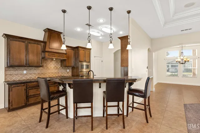 a kitchen with stainless steel appliances kitchen island granite countertop a stove a sink and a refrigerator