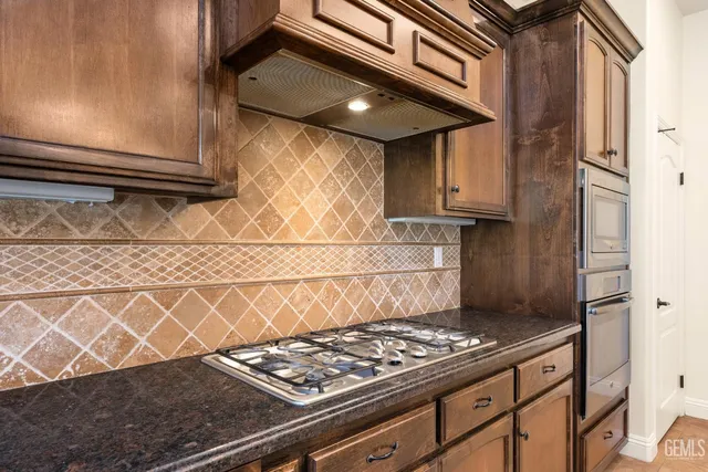 a kitchen with stainless steel appliances granite countertop a stove a refrigerator and a stove